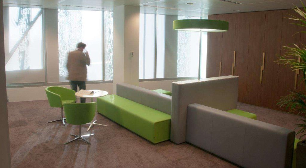 loungehoek met geometrische vormen in hard groen en grijs. Geintegreerd met staande lamp.